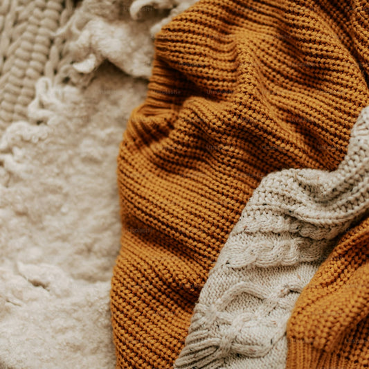 Chunky cable knit throw blanket in neutral tones